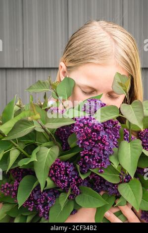 Nahaufnahme des jungen Mädchens, das einen Haufen Flieder hält Blumen Stockfoto