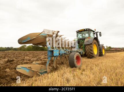Bauer in einem Traktor pflügt ein Feld im Spätsommer. Perry Green, Much Hadham, Hertfordshire. VEREINIGTES KÖNIGREICH Stockfoto