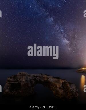 Natursteinbogen 'Es Pontàs' mit der Milchstraße auf Mallorca. Astrofotografie Konzept Stockfoto