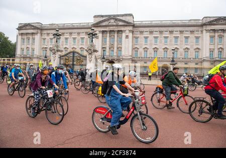 Radfahrer starten vor dem Buckingham Palace während eines Extinction Rebellion Protestes in London. Die Umweltkampagnengruppe hat Veranstaltungen geplant, die an mehreren Sehenswürdigkeiten der Hauptstadt stattfinden sollen. Stockfoto