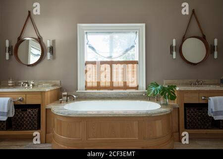 Rustikales Badezimmer mit Badewanne zwischen Waschbecken Stockfoto