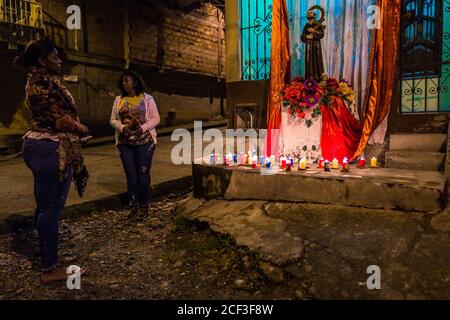 Afro-kolumbianische katholische Anhänger beten vor einem Straßenaltar während des San Pacho Festivals in Quibdó, Kolumbien. Stockfoto