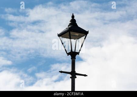 Ein Laternenpfosten vor einem blauen Himmel mit weißen Wolken in Hugh Town, St. Mary's, Isles of Scilly Stockfoto