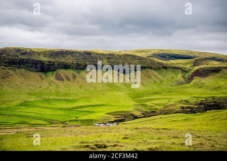 Klippe in Fjädrargljufur, Island mit Blick auf den Parkplatz Autos von grünem Moos Gras Landschaft Blick auf bewölkt stürmischen Tag mit Wolken am Himmel Stockfoto