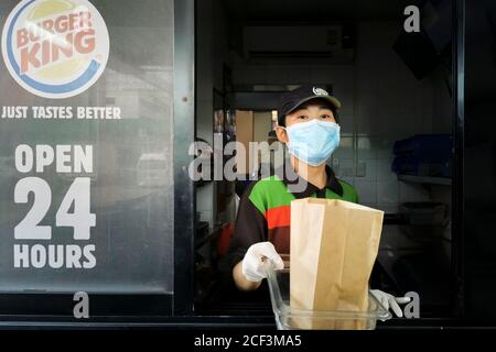 Bangkok, Thailand - September 3, 2020 : Burger King Fast Food Kassierer Drive-Thru-Service trägt Gesichtsmaske zu Coronavirus Pandemie oder covid-19 zu schützen Stockfoto