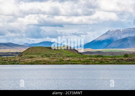 Landschaftsansicht von Island See Myvatn Berge in Skutustadagigar während wolkiger Tag und ruhige ruhige Wasser und Hügel im Sommer Stockfoto