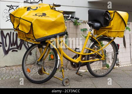 Fahrrad eines Postboten der Deutschen Post steht Auf dem Bürgersteig Stockfoto
