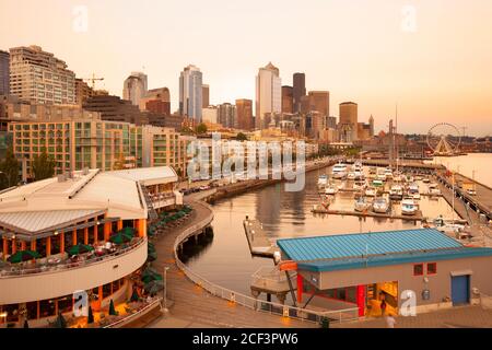 Seattle, Washington, USA - Überblick über das Wasser in der Innenstadt mit dem Yachthafen, einem Restaurant im Dock und der Skyline der Stadt. Stockfoto