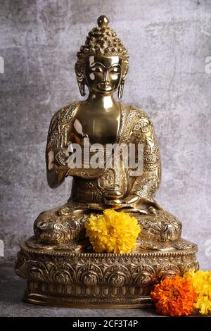 Messingskulptur von Gautam Buddha. Auf grauem Hintergrund Stockfoto