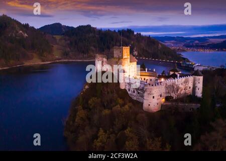 Landschaftlich schöne Aussicht auf die alte Festung Dunajec Castle auf der Spitze Hügel über Czorsztyn See in der polnischen Stadt Niedzica bei Abenddämmerung Stockfoto