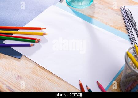 Weißes Papier mit Farbstiften auf Holztisch mit Kopieplatz reinigen. Kreativitätskonzept Stockfoto