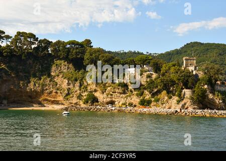 Blick vom Meer der Küste mit dem Schloss von San Terenzo (16. Jahrhundert) auf einem felsigen Sporn im Sommer, La Spezia, Ligurien, Italien Stockfoto