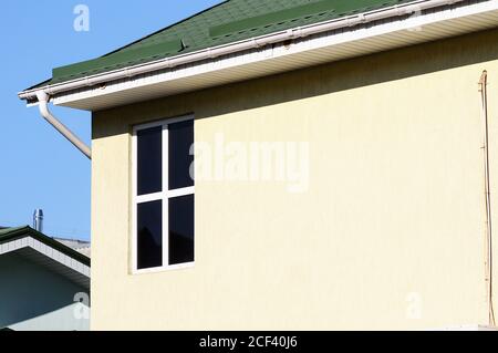 Weiße Dachrinne auf dem Metalldach des Hauses. Stockfoto