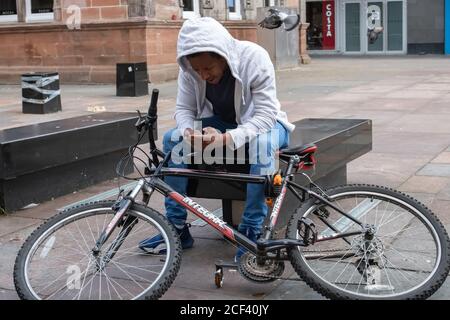 Glasgow, Schottland, Großbritannien. September 2020. Wetter in Großbritannien. Ein Radfahrer keckckt sein Telefon auf dem St. Henoch Platz. Kredit: Skully/Alamy Live Nachrichten Stockfoto