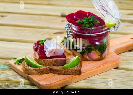 Hausgemachte eingelegte Blauen Wittling fischen, Zwiebeln, Rüben und Marinade aus Zitronensaft und Olivenöl Stockfoto