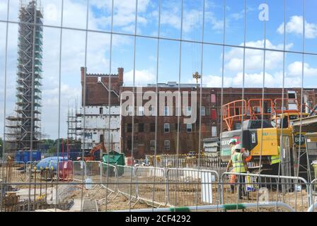 Renovierungsarbeiten in der Horlicks Factory, Slough, Berkshire, Großbritannien. Schornstein in Gerüst bedeckt. Stockfoto