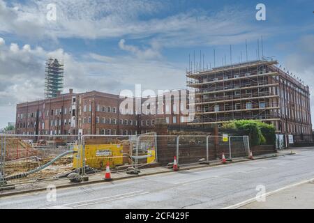 Renovierungsarbeiten in der Horlicks Factory, Slough, Berkshire, Großbritannien. Schornstein in Gerüst bedeckt. Stockfoto