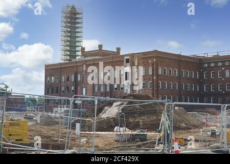 Renovierungsarbeiten von Berkley Homes in Arbeit in der Horlicks Factory, Slough, Berkshire, Großbritannien Schornstein mit Gerüsten bedeckt wird erhalten. Stockfoto