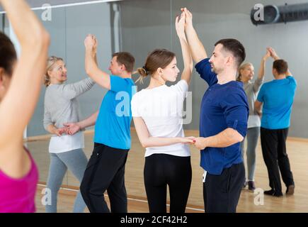 Gruppe von glücklichen erwachsenen Menschen tanzen moderne Gesellschaftstänze in Paar in der Tanzschule Stockfoto