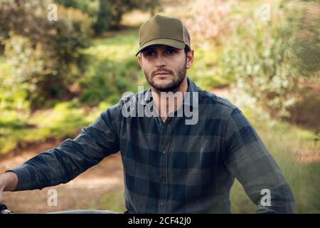 Mountainbiker Sportler ohne Schutz sitzen auf dem Fahrrad in der Mitten in einem Wald mit Blick weg Stockfoto