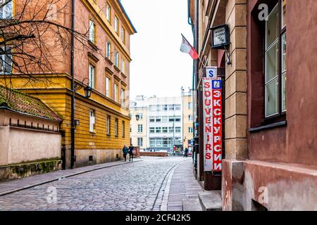 Warschau, Polen - 25. Dezember 2019: Altstadt historische Straße Straße Gasse mit Schild für Souvenir und Ausflug Tour Store Eingang und polnische Flagge Stockfoto