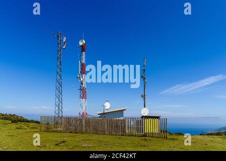 Telekommunikations- und Telefonantenne in grüner Landschaft auf Hügel Stockfoto