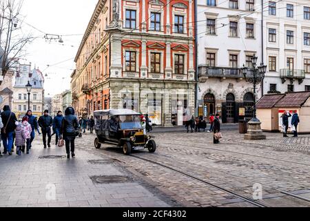 Lviv, Ukraine - 21. Januar 2020: Trolley-Tram-Tracks in der historischen ukrainischen Stadt Lvov in der Altstadt mit Menschen Reiten vintage Retro-Auto Trolley-Tour Stockfoto