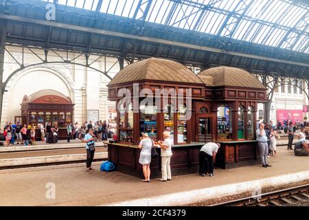 Lviv, Ukraine - 30. Juli 2018: Innenarchitektur des Bahnhofs Lvov Bahnsteig mit Kiosk-Shop und Menschen warten mit Gepäck im historischen Ukrai Stockfoto