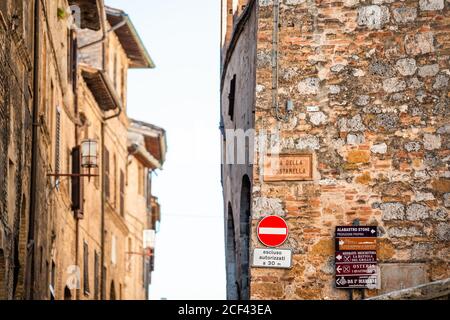 San Gimignano, Italien - 27. August 2018: Enge Gasse in historischen mittelalterlichen Altstadt Dorf in der Toskana mit niemand und Wegweiser für Resta Stockfoto