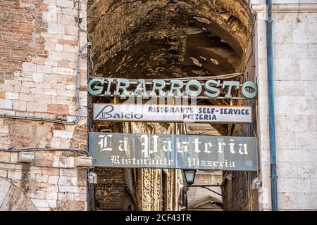 Perugia, Italien - 29. August 2018: Historische alte etruskische Gebäude der Stadt Dorf mit engen Steinallee und Restaurant Zeichen Stockfoto