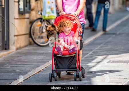 Assisi, Italien - 29. August 2018: Menschen Touristen auf der Straße mit Baby Kind und Hund lustig zusammen in Kinderwagen in Umbrien Stadt Dorf Stockfoto