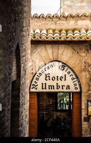 Assisi, Italien - 29. August 2018: Straße Gasse in Umbrien Stadt Dorf mit niemand und Schild für Hotel Umbria mit Restaurant Eingang Stockfoto