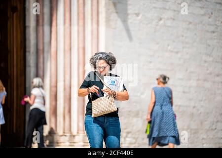Assisi, Italien - 29. August 2018: Frau Menschen Touristen in Umbrien Stadt Dorf durch berühmte Kirche Eingang im Sommer offen Stockfoto