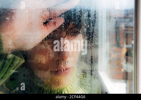 Melandimorisch junge Frau, die durch das Fenster schaut Stockfoto