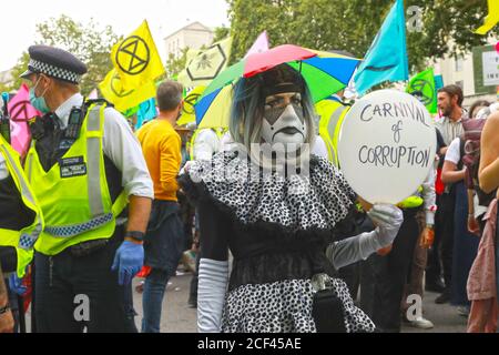 Westminster, Großbritannien. September 2020. Tag drei des Aussterbens Rebellionen Klima-Campign und Demonstrationen in Zentral-London. Heute hielten sie einen "Karneval der Korruption" Aktivisten kamen als Clowns und Zirkusdarsteller einschließlich eines Ringmeisters, sie warfen gefälschte momey um das "darty Geld" in Branchen wie t = Öl zu markieren. Quelle: Natasha Quarmby/Alamy Live News Stockfoto