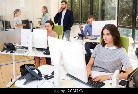 Erwachsene seriöse Geschäftsleute arbeiten und kommunizieren zusammen in modernen Großraumbüro Stockfoto