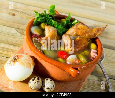Köstliche solyanka auf Brühe von der Wachtel mit Schinken, Tomaten, Oliven und Wachteleier mit frischen Kräutern serviert. Stockfoto