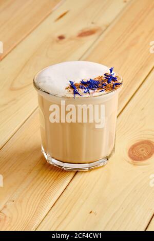 Flacher weißer Kaffee in transparentem Glas auf Holzhintergrund Stockfoto