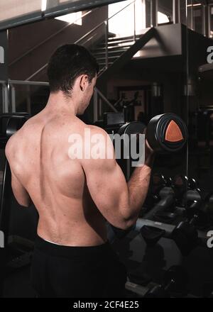 Junge Fitness-Mann, die Maschine Gewichte in der Turnhalle Stockfoto