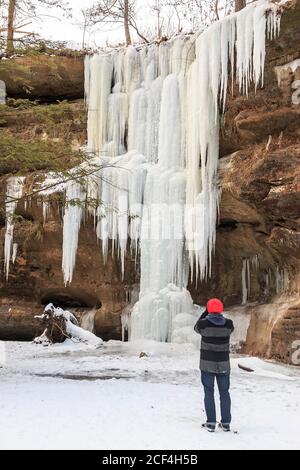 Besucher fotografiert gefrorene Lower Falls im Winter am alten Mann Höhle, Hocking Hills State Park, Ohio. Stockfoto