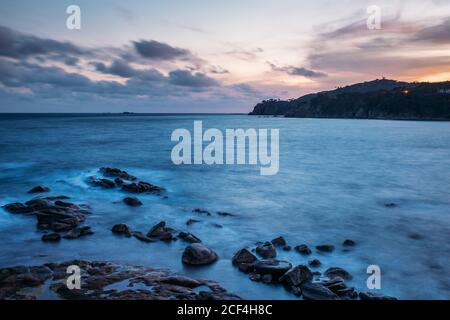 Glatte Steine am Ufer der endlosen Meer Waschinsel in bewölktem Tag in Calella de Palafrugell, Costa Brava, Girona, Katalonien, Spanien Stockfoto