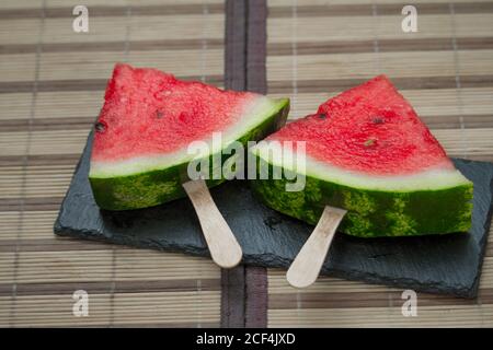 Wassermelonenscheibe auf schwarzer Steinplatte, Eiscreme-Konzept, selektiver Fokus Stockfoto