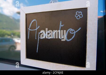 Aperto (Offen) Inschrift auf Tafel zeichnen und vor einem Bistro in Riva San Vitale, Schweiz, hängen Stockfoto