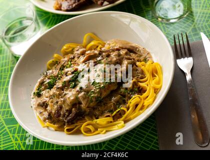 Traditionelle französische Gebratene Rippchen serviert mit Pilzsauce und Linguine Stockfoto