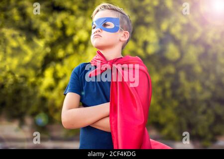 Superheld Kind Junge vor grünem Hintergrund im Freien. Kindheit, Erfolg und Machtkonzept Stockfoto