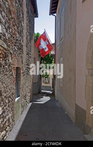 Schweizer Flagge in der Mitte einer Gasse im Zentrum von Riva San Vitale, Schweiz Stockfoto