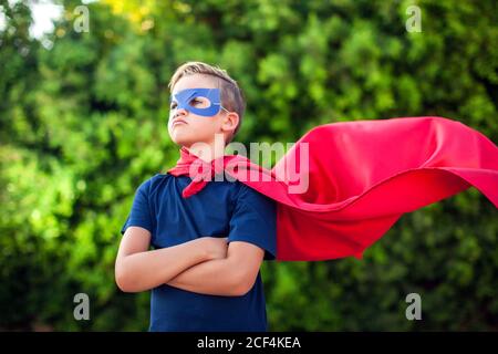Superheld Kind Junge vor grünem Hintergrund im Freien. Kindheit, Erfolg und Machtkonzept Stockfoto