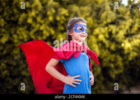 Superheld Kind Mädchen vor grünem Hintergrund im Freien. Kindheit, Erfolg und Machtkonzept Stockfoto