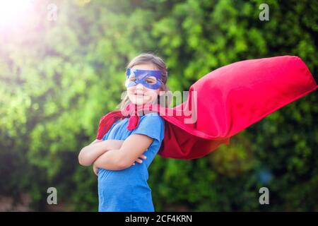Superheld Kind Mädchen vor grünem Hintergrund im Freien. Kindheit, Erfolg und Machtkonzept Stockfoto