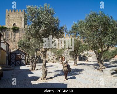 Tourist Spaziergang zwischen hundertjährigen Olivenbäumen in den Gärten von Schloss Óbidos - Bezirk Leiria - Portugal Stockfoto